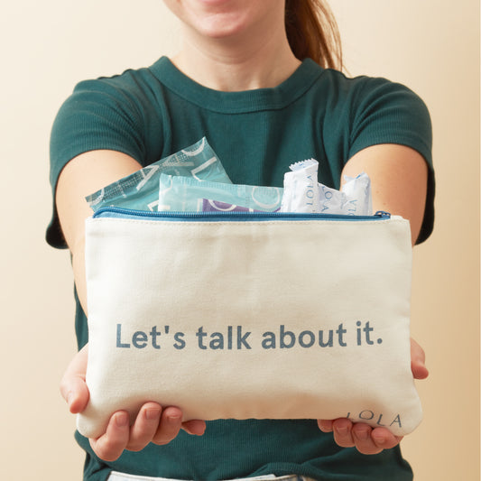 Person holding a pouch with 'Let's talk about it.' text and LOLA branding.